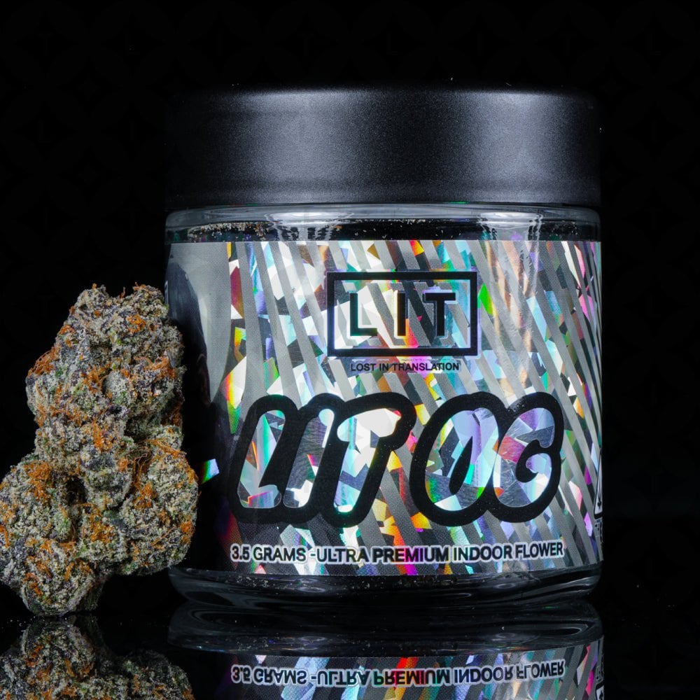 Glass jar with holographic label and cannabis flower bud displayed beside it against black background