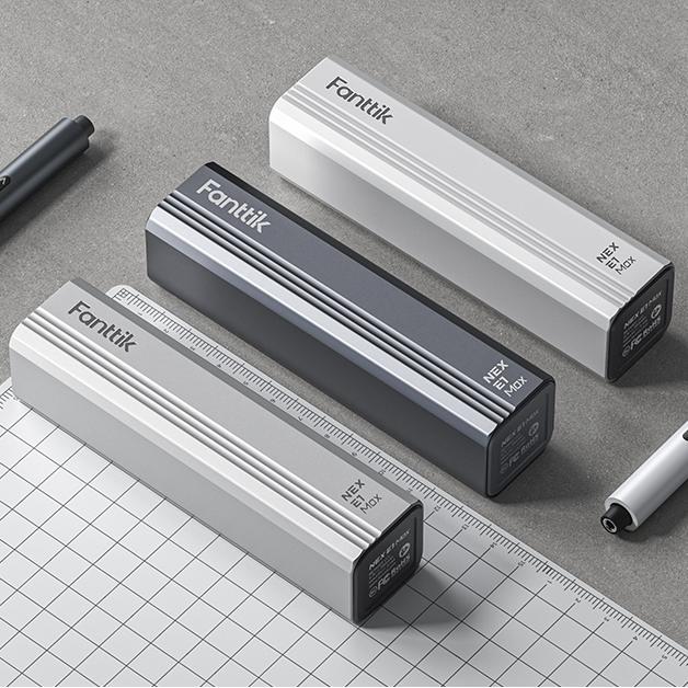 Three white and gray cylindrical tire inflators with Fanttik branding arranged on a ruler and grid paper