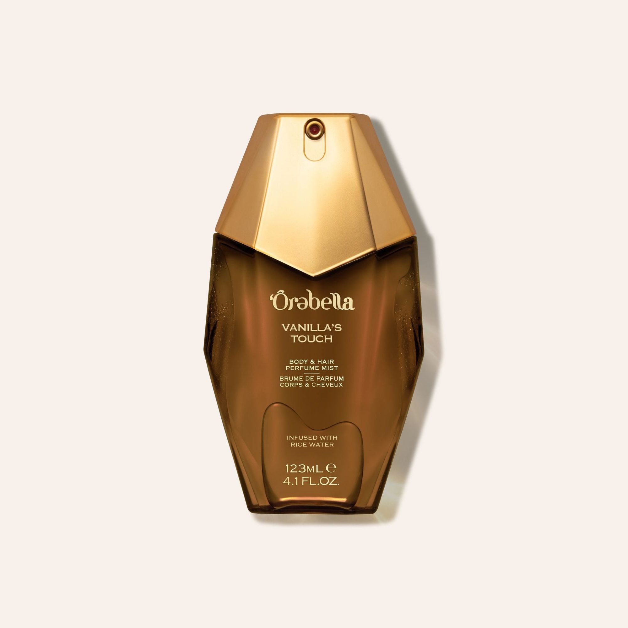 Brown glass bottle with gold cap labeled Vanilla's Touch body and hair perfume mist